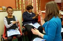 Small group of people learning to fingerspell